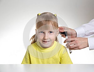 An otolaryngologist examines the ear of a child girl at the age of 5 years. Otoscopy, copy space for text