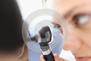 An otolaryngologist examines the patient ear closeup