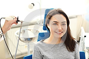 Otolaryngologist examining woman's ear with ENT telescope in hospital