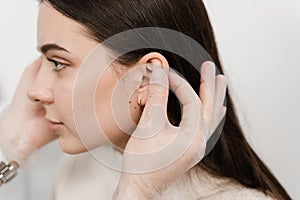 Otoplasty ear surgery. Surgeon doctor examines girl ears before otoplasty cosmetic surgery. Otoplasty surgical reshaping of pinna
