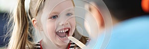 Otorhinolaryngologist doctor examining sore throat little girl in clinic photo