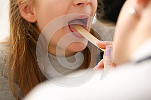 Otorhinolaryngologist examines child girl with sore throat