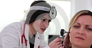 Otoscope examination of the ear canal and eardrum in a woman