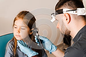 Otoscopy of child ears with otoscope. ENT doctor. Consultation with pediatric otolaryngologist. Treatment of childs ear