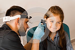 Otoscopy of child ears with otoscope. ENT doctor. Consultation with pediatric otolaryngologist. Treatment of childs ear