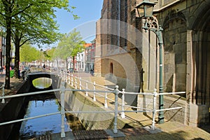 The Oude Delft canal with the external facade of Oude Kerk on the right side, Delft