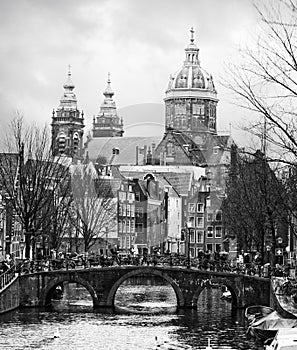 Oudezijds Voorburgwal canal  in the center of Amsterdam. In the background Basilica of St. Nicholas. Black and white