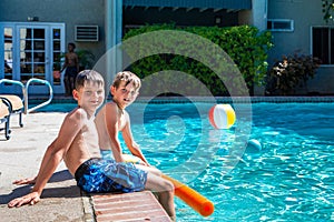 Oudoor summer activity. Concept of fun, health and vacation. Brothers boys eight and five years old with noodle sits