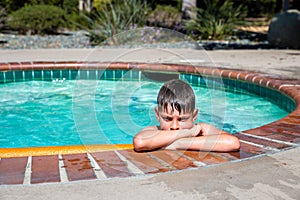 Oudoor summer activity. Concept of fun, health and vacation. A sad boy eight years old in swimming goggles is holding