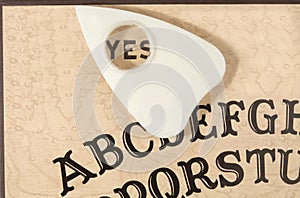 Ouija board with the planchette pointing to YES