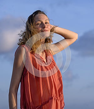 Oung happy beautiful and glamorous blond woman posing as at the beach wearing stylish dress smiling cheerful feeling fresh and fre