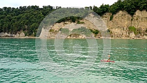 Ð¡ouple surfers on supboard floating along shore on azure sea. Aerial view