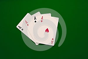 our aces poker cards close up on green backgorund. Four of a kind conbination in pocker game.