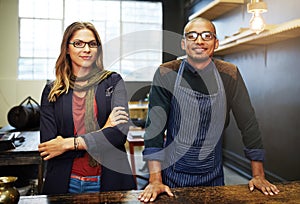 Our business partnership has been a success. Portrait of two young businesspeople standing in their shop.