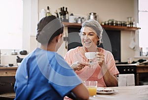 Our chats are the highlight of my day. a young female caregiver chatting to a senior patient in a nursing home.