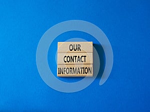 Our contact information symbol. Concept word Our contact information on wooden blocks. Beautiful blue background. Business and Our