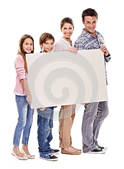 Our family values this. Studio shot of a happy family standing with a big blank placard for copyspace.