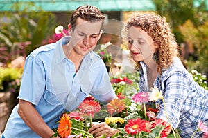 Our gardens going to look amazing. A happy couple choosing flowers in a nursary.