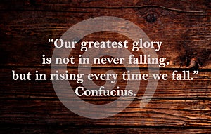 Our greatest glory is not in never falling, but in rising every time we fall. Inspirational quote on vintage retro background.