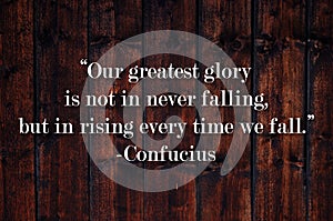 Our greatest glory is not in never falling, but in rising every time we fall.  Inspirational quote on vintage retro background.