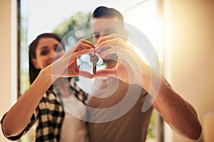 Our home will be filled with so much love. Portrait of a young couple holding the keys to their new home.