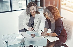 Our idea brought more viewers to the site. two businesswomen discussing something on a digital tablet.