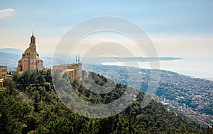 Our Lady of Lebanon Maronite church sits on a hill over the Jounieh bay, with Beirut capital city in the background, in Lebanon,