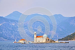 Our Lady of the Rocks church on island in Boka Kotor bay near Perast town and mountains, Adriatic Sea, Montenegro