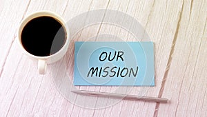 OUR MISSION text on the blue sticker with cofee and pen