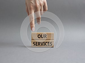 Our services symbol. Concept words Our services on wooden blocks. Beautiful grey background. Businessman hand. Business and Our