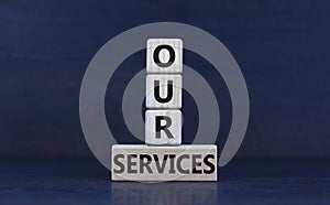 Our services symbol. Wooden cubes and block with words `our services` on beautiful grey background. Business and our services