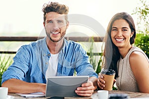 Our smartest tools always accompany us. Portrait of two businesspeople using a digital tablet together outdoors.