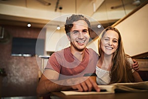 Our studies have brought us closer. Portrait of a happy young student couple studying together at a cafe.