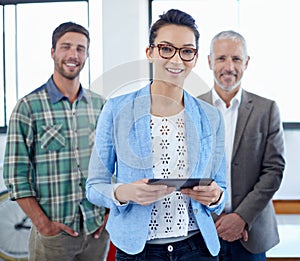 Our teams secret weapon. Portrait of a group of colleagues standing in an office.