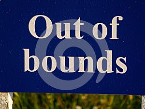 Out of bounds sign on golf course bold white lettering on royal blue background