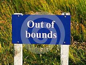 Out of bounds sign on golf course bold white lettering on royal blue background