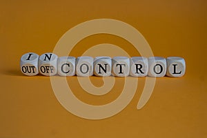 In or out of control symbol. Concept words In control and Out of control on wooden cubes.