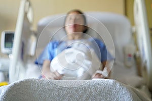 Out of focus image of Asian chinese woman patient lying in hospital ward