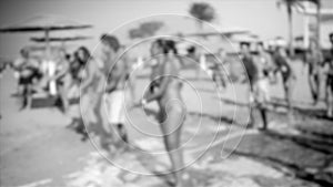 Out of focus image of cheerful young people dancing and having fun on the sea beach disco party. Silhouette of big crowd