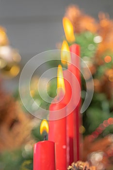 Out of focus photo. Blurred. Advent. Christmas cards. Four red burning candles. Decorated Christmas tree background. Christmas
