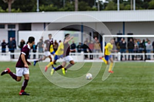 Out of focus shot of teenagers playing soccer football on the