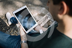 Out of focus young man holding tablet with blank screen