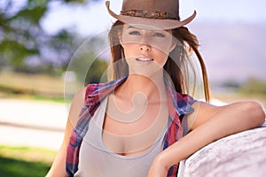 Out here is where I belong. A beautiful cowgirl standing outdoors on a Summers day.