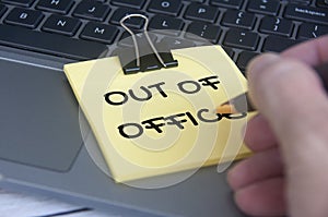 Out of office notification text sticky notes with laptop background. Out of Office concept