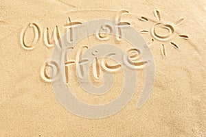 Out of office sign on beach sand