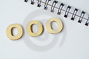 Out of Office wooden text on white notepad.