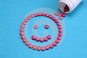 Out of pink pills laid out face with a smile photo