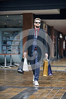 Out and about on a serious shopping spree. a well dressed young man on a shopping spree.
