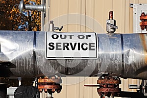 An Out of Service sign on an oil pipeline