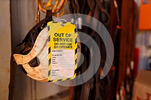 Out of service tag attached on faulty defect safety fall protection abseiling helmet